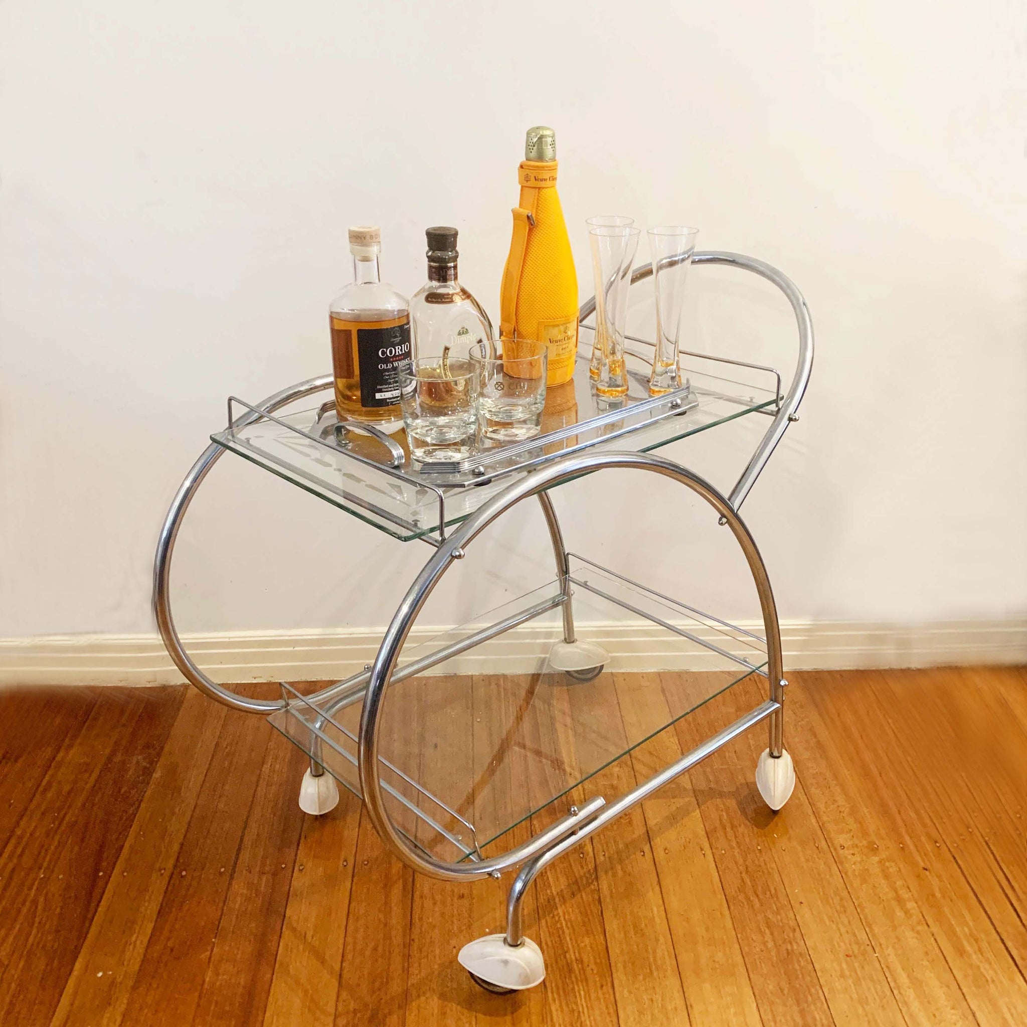 Australian art deco chrome and glass bar cart with bakelite wheel skirts