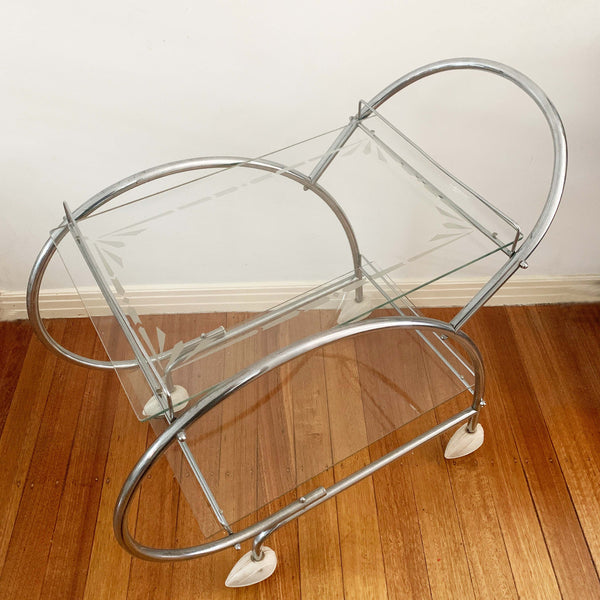 Australian art deco chrome and glass bar cart with bakelite wheel skirts