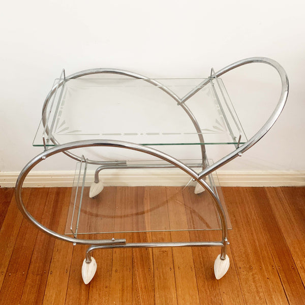 Australian art deco chrome and glass bar cart with bakelite wheel skirts