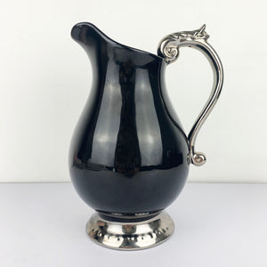 Large black ceramic jug with silver scroll handle