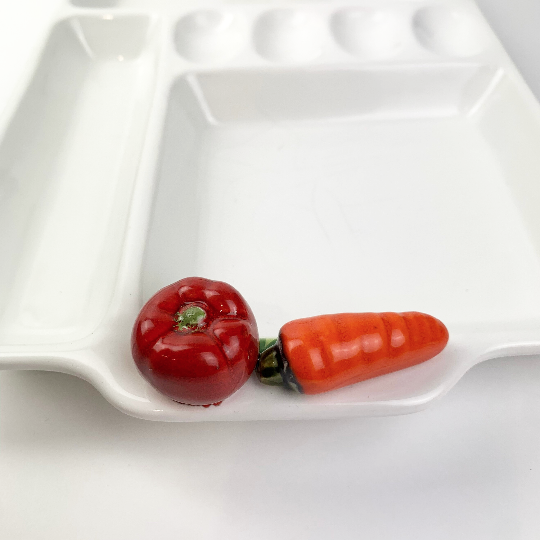 Ceramic vegetables on rim of Italian platter