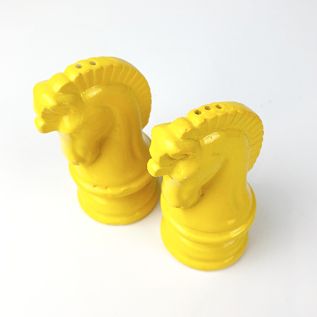 Yellow salt and pepper shakers showing top holes