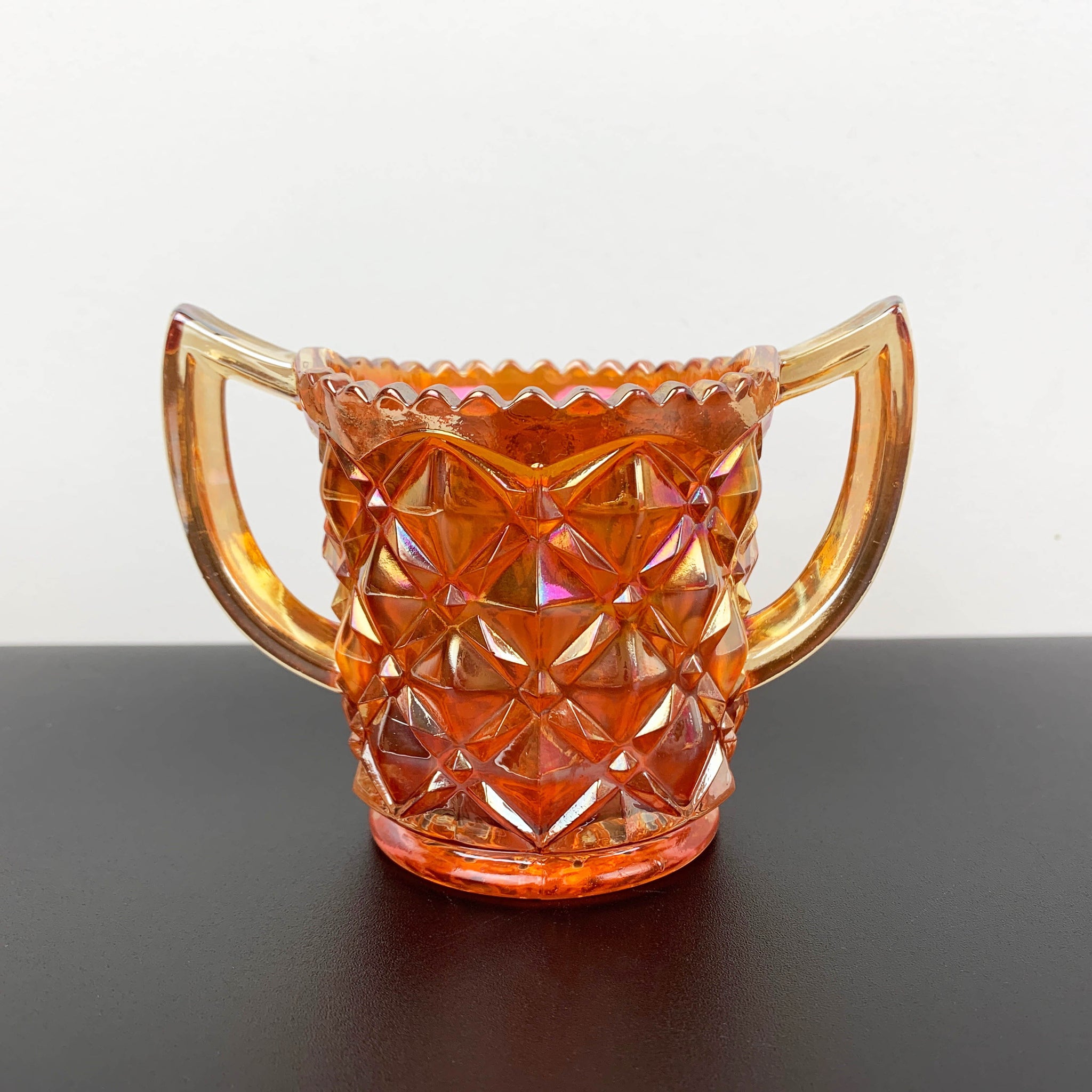 Marigold carnival glass twin handled sugar bowl with sawtooth rim